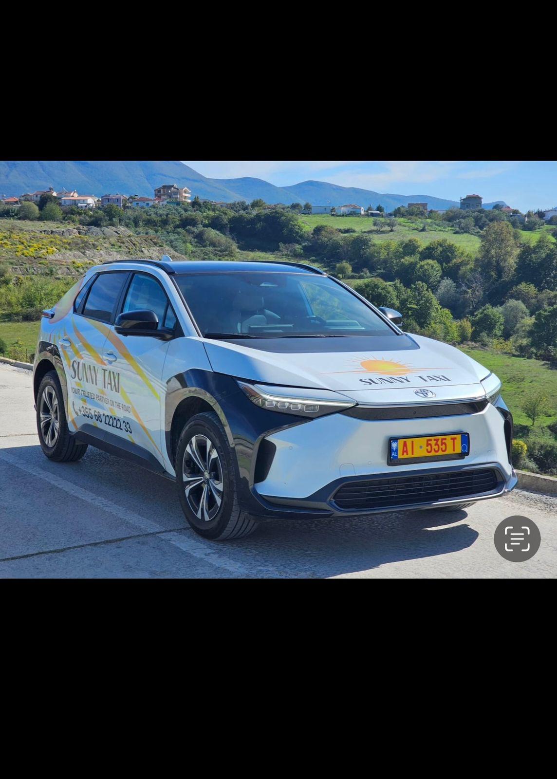 Modern yellow taxi with Albanian landscape